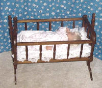Lee Middleton doll in wooden baby doll cradle